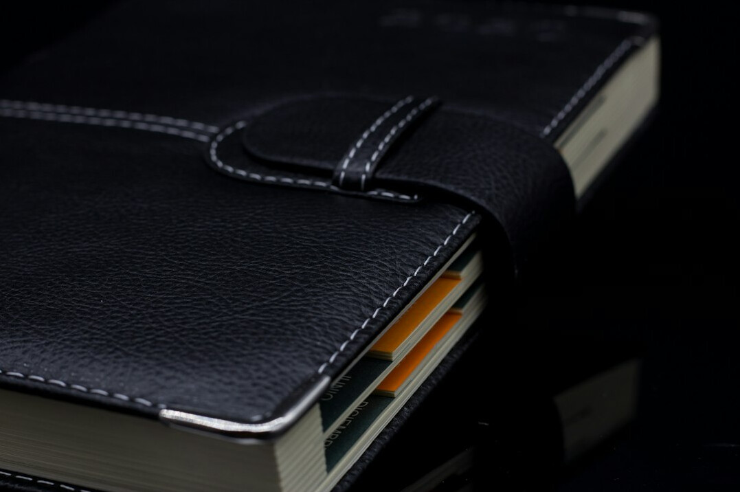Open notebook with a pen on a wooden desk